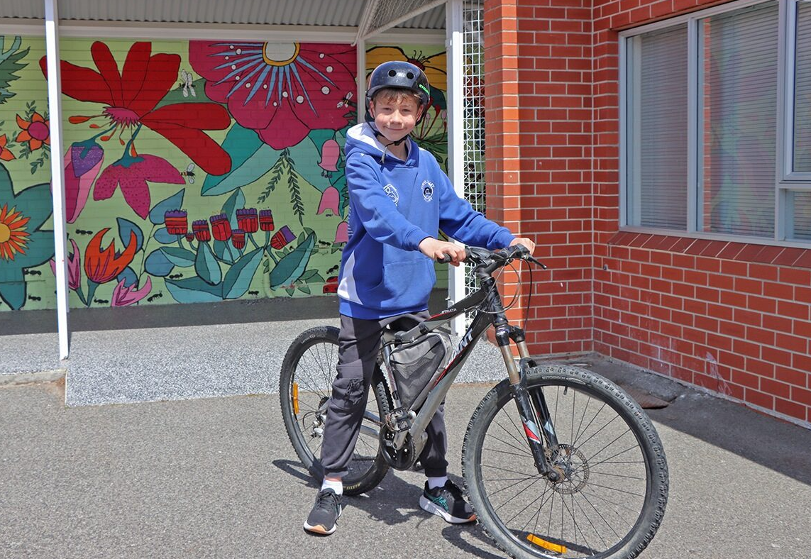 A student from Lenah Valley Primary School holding a bicycle